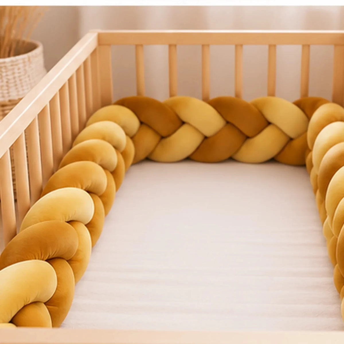 Tour de lit bébé tressé, coloris Jaune moutarde, installé dans un lit bébé en bois