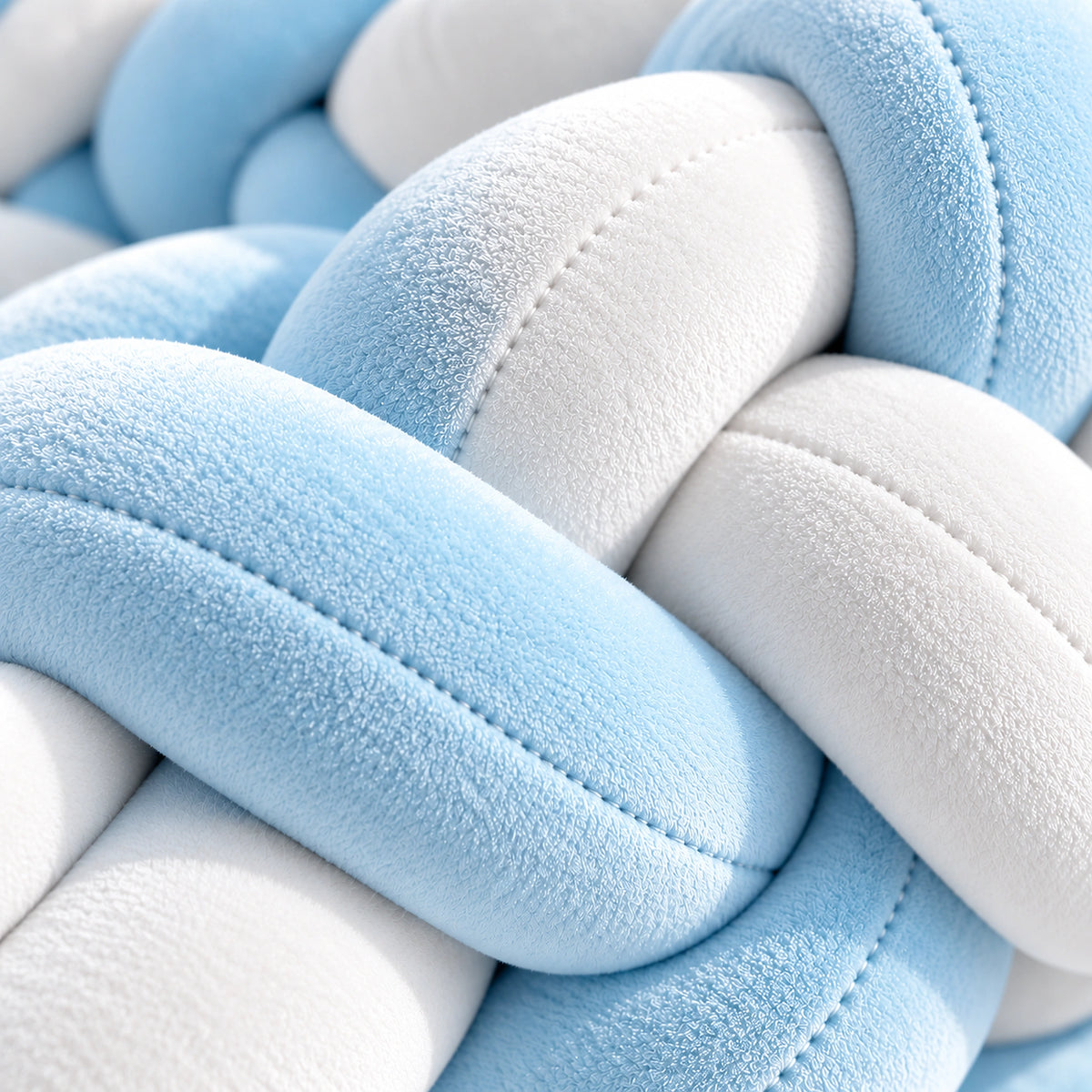 Gros plan sur la texture du tour de lit bébé tressé bleu ciel et blanc