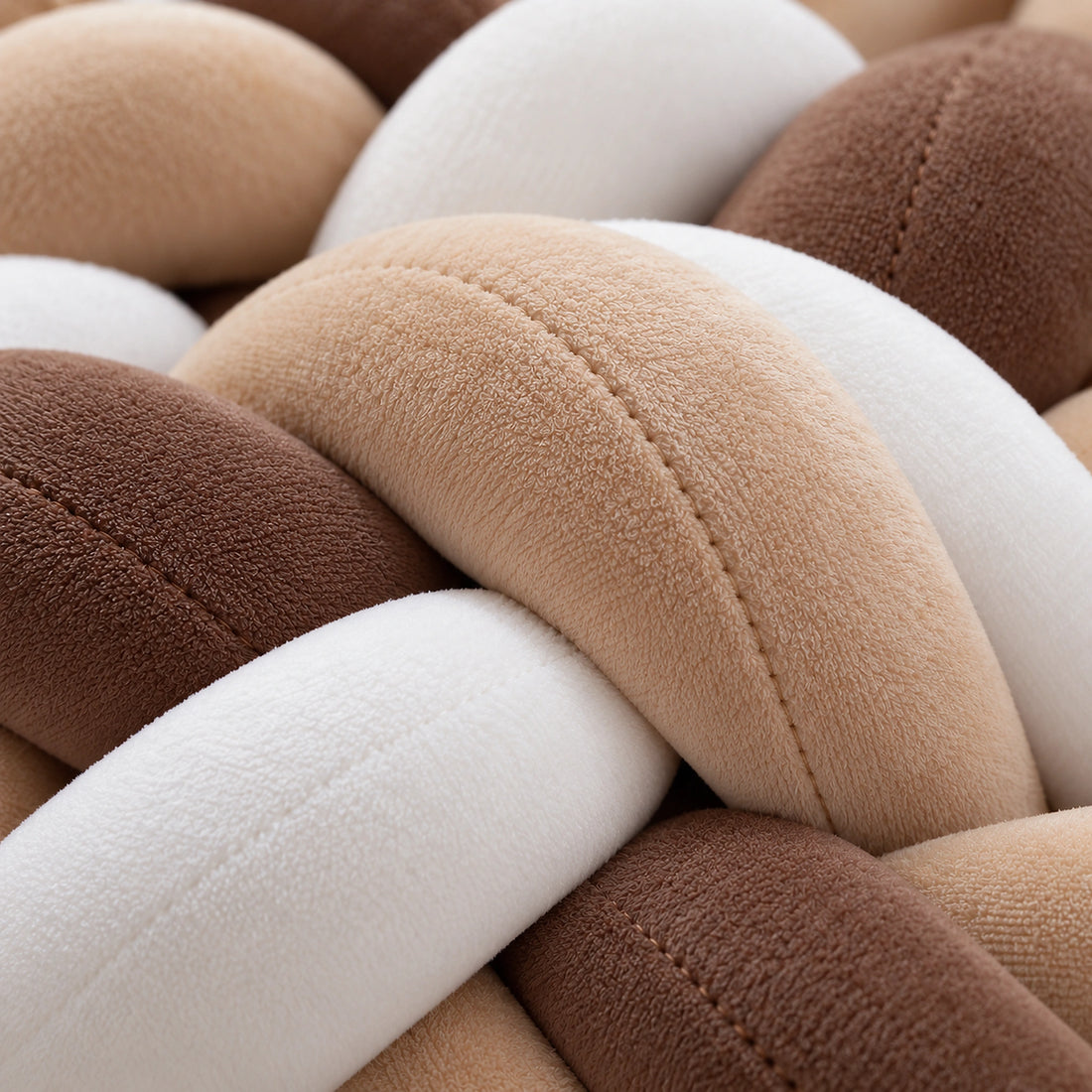 Gros plan sur la texture du tour de lit bébé tressé caramel et blanc