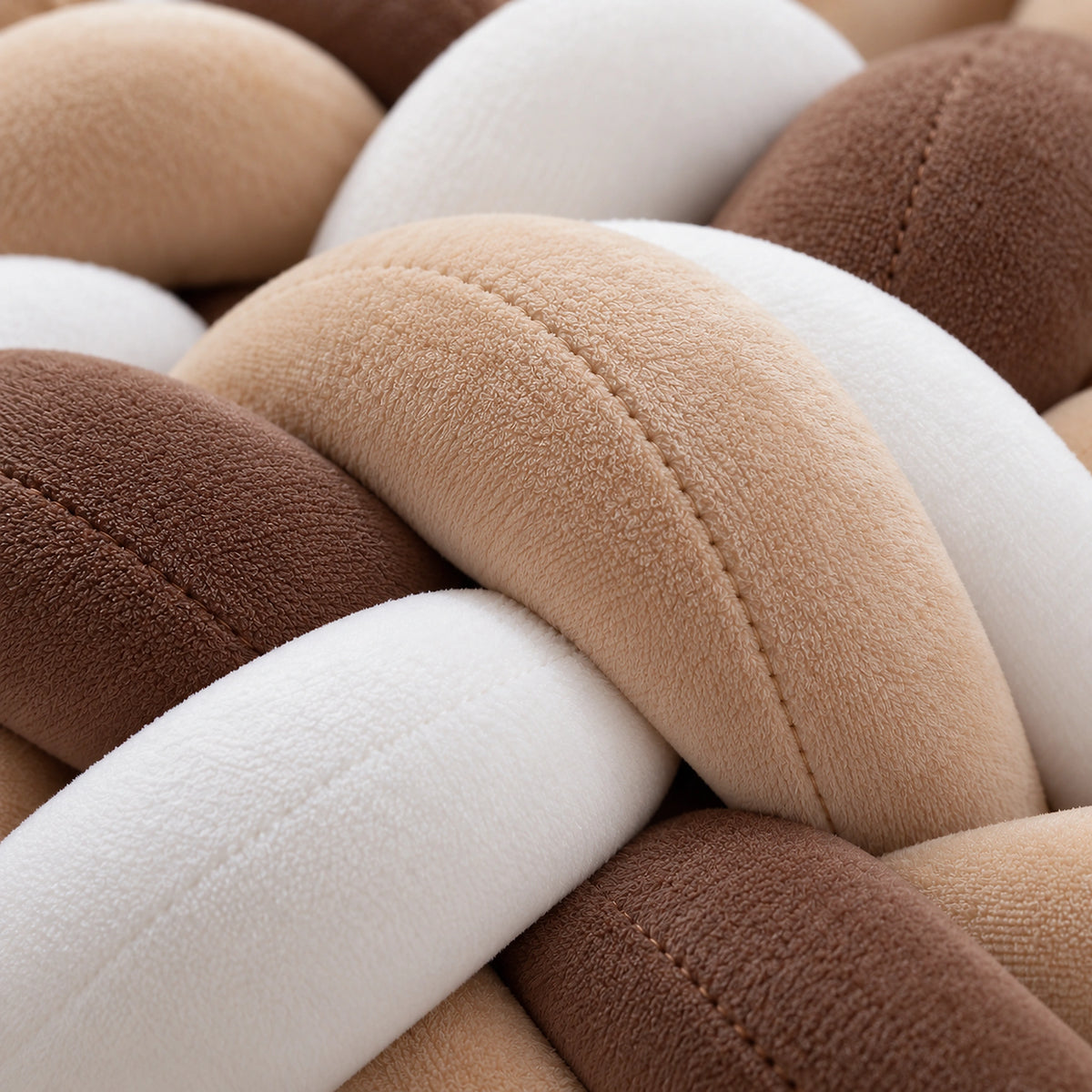 Gros plan sur la texture du tour de lit bébé tressé caramel et blanc