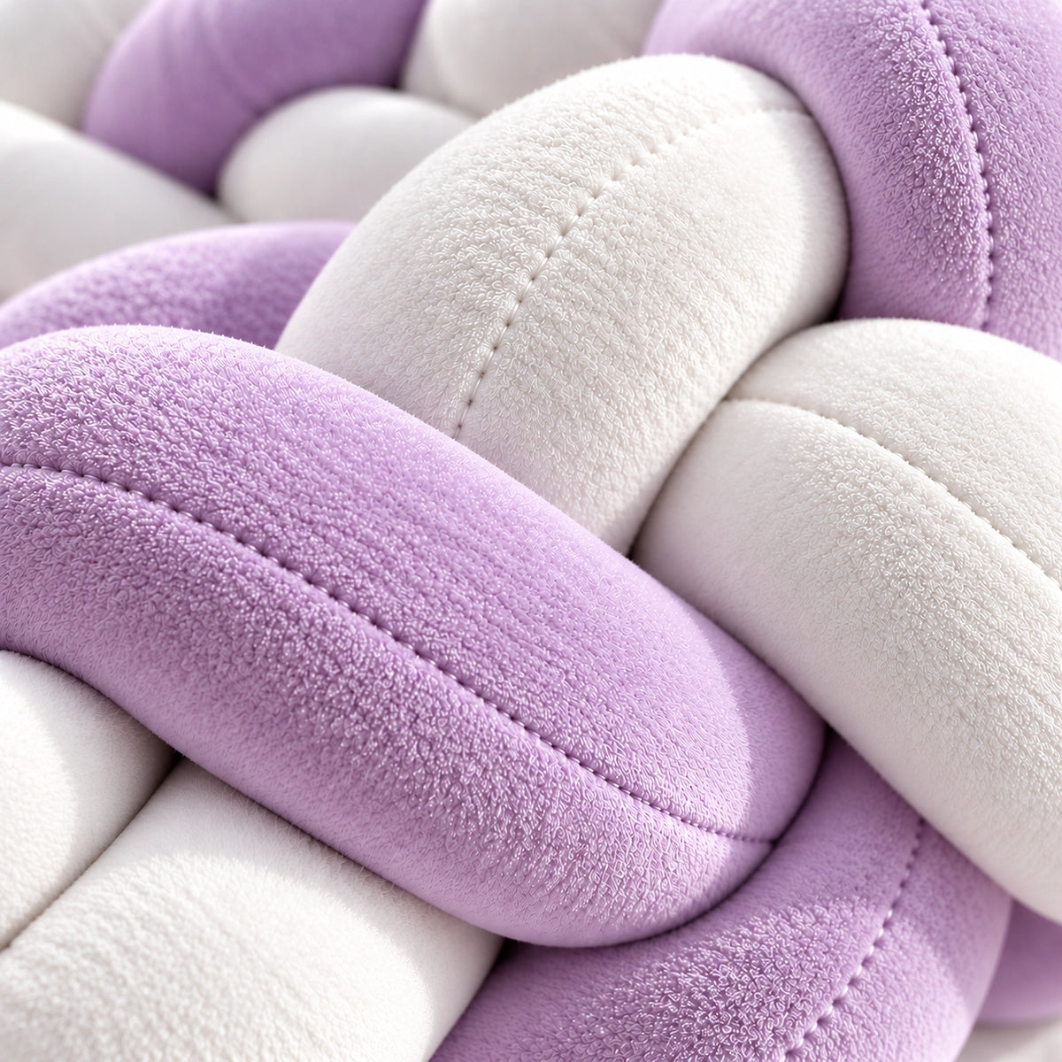 Gros plan sur la texture du tour de lit bébé tressé lilas et blanc